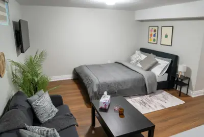 a living room with a bed and a coffee table at Studio Apartment B - Full Kitchen - Cozy and Modern in Brampton