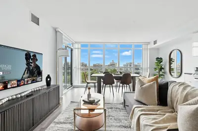 a living room with a tv and a table with chairs at Modern 2BR Condo Stunning Views Walk Everywhere in Toronto