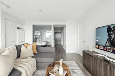 a living room with a couch and a tv at Modern 2BR Condo Stunning Views Walk Everywhere in Toronto