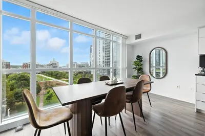 a dining room with a table and chairs and large windows at Modern 2BR Condo Stunning Views Walk Everywhere in Toronto