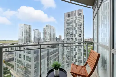 an apartment balcony with a chair and views of the city at Family-Friendly Sleep 8 Steps to all Attractions in Toronto