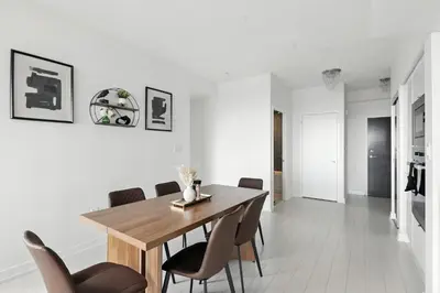 a dining room with a wooden table and chairs at Family-Friendly Sleep 8 Steps to all Attractions in Toronto