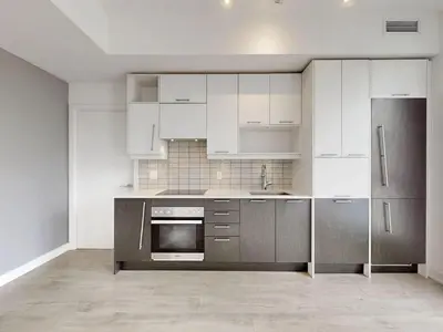 a kitchen with white cabinets and stainless steel appliances at Ritzdale Suites - Toronto's Entertainment District in Toronto