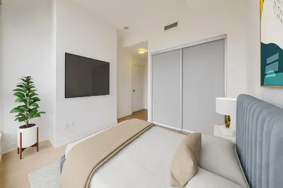 a living room with a couch and a tv at Ritzdale Suites - Toronto's Entertainment District in Toronto