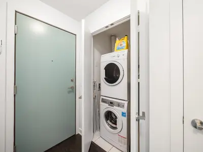 a laundry room with a washer and dryer at Ritzdale Suites - Toronto's Entertainment District in Toronto