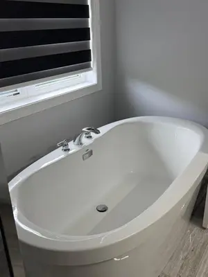 a white bath tub in a bathroom with a window at masters bet room in Whitby