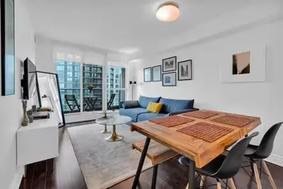 a living room with a blue couch and a table at Lakeview 1-Bedroom Condo-Downtown Toronto-Free Parking in Toronto