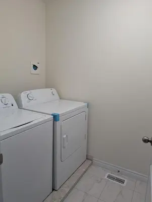 a white laundry room with a washer and dryer at Modern 3BR Home Near Niagara Falls & Welland Canal in Welland