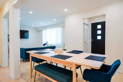a dining room with a table and blue chairs at Bright, Modern & Cozy Getaway Home in the GTA in Whitby