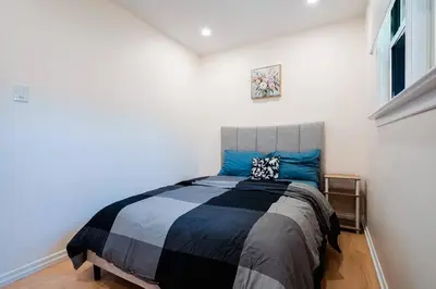 a bedroom with a large bed with blue pillows at Bright, Modern & Cozy Getaway Home in the GTA in Whitby