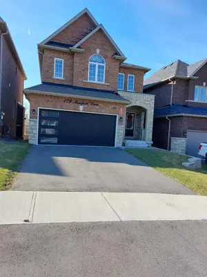 a house with a large garage in the driveway at Modern 5-bedroom house close to Ardagh Bluffs in Barrie