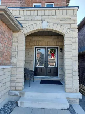 a front door of a house with a brick wall at Modern 5-bedroom house close to Ardagh Bluffs in Barrie