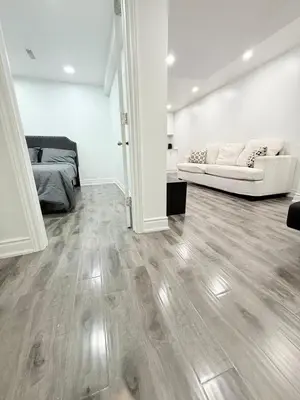 a living room with wooden floors and white walls at Modern & cozy one Bedroom Basement Suite with Kitchen and parking- sleeps 4 in Mississauga