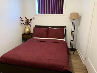 a bedroom with a bed with a red blanket at Bright Escape Falls Retreat in Niagara Falls