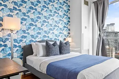 a bedroom with a bed with a blue and white wallpaper at Chic Fort York Studio Cozy Retreat in Downtown TO in Toronto