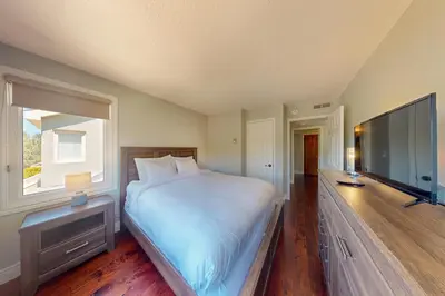 a bedroom with a large bed and a flat screen tv at Wintergreen 222 in Blue Mountains