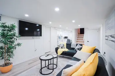 a living room with a couch and a tv at Stylish, Spacious 6-Bedroom Home in the GTA in Whitby
