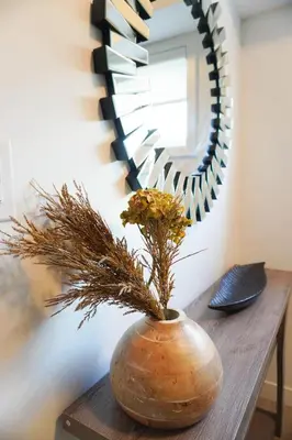 a vase with a plant on a table in front of a mirror at Entire 3 bedroom townhouse in Cambridge