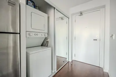 a kitchen with a washer and dryer next to a door at High Floor 1 Bedroom Condo City View Downtown Toronto in Toronto