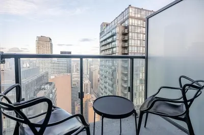 two chairs and a table on a balcony with a view at High Floor 1 Bedroom Condo City View Downtown Toronto in Toronto