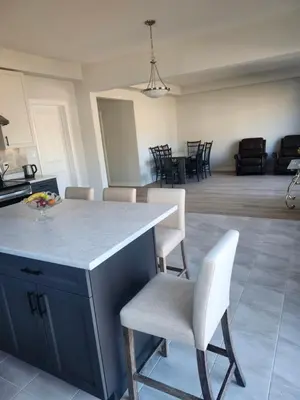 a kitchen and living room with a counter and chairs at Sunrise Villa in Fort Erie