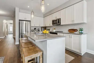 a kitchen with white cabinets and a counter top at Family Townhome in Historic Snowbridge in Blue Mountains