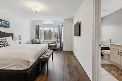 a bedroom with a large bed and a bathroom at Family Townhome in Historic Snowbridge in Blue Mountains