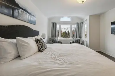 a bedroom with a large white bed with two pillows at Family Townhome in Historic Snowbridge in Blue Mountains