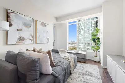 a living room with a couch and a large window at Modern Lakeside 1BR Condo in Downtown Toronto in Toronto