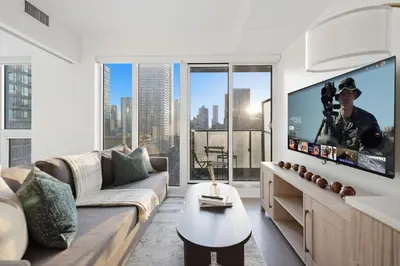 a living room with a couch and a flat screen tv at Bright 2BR Condo w Patio Central Toronto Retreat in Toronto