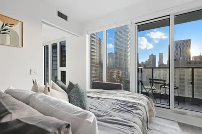 a bedroom with a bed and a large window at Bright 2BR Condo w Patio Central Toronto Retreat in Toronto