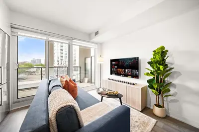 a living room with a blue couch and a large window at City Living Downtown Retreat Perfect Getaway in Toronto