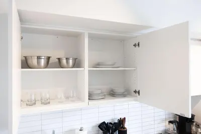 a kitchen with white cabinets with bowls and plates at City Living Downtown Retreat Perfect Getaway in Toronto