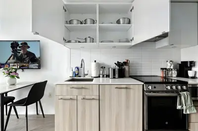 a kitchen with white cabinets and a black oven at Luxe Downtown Studio Near Eaton Centre & Transit in Toronto