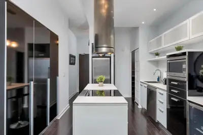 a kitchen with white cabinets and a white counter top at Glamorous City Escape King Bed & CN Tower Views in Toronto