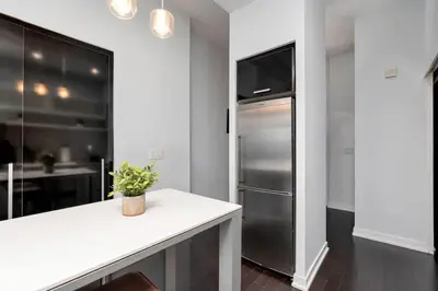 a kitchen with a stainless steel refrigerator and a counter at Glamorous City Escape King Bed & CN Tower Views in Toronto