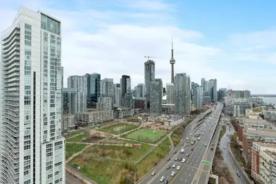 a view of a city with a highway and buildings at Glamorous City Escape King Bed & CN Tower Views in Toronto