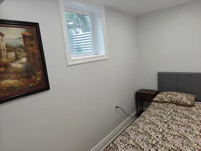 a bedroom with a bed and a painting and a window at Pleasant stay Mississauga in Mississauga
