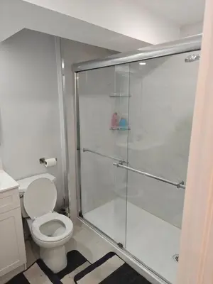 a bathroom with a toilet and a glass shower at Pleasant stay Mississauga in Mississauga