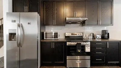 a kitchen with stainless steel appliances and wooden cabinets at Modern Bay Vista Getaways in Carrying Place