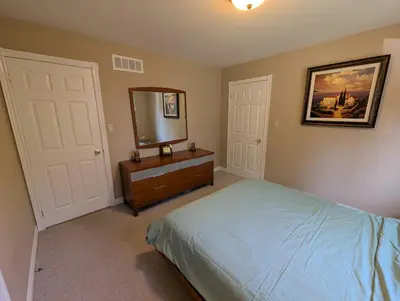 a bedroom with a bed and a mirror and a dresser at Red Brickhouse Lakefront Cottage in Brechin