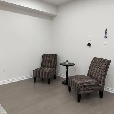 two chairs and a table in a room at Lux 3 Bedroom Home near Public Transit in Brampton