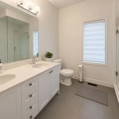a bathroom with a sink and a toilet and a mirror at Lux 3 Bedroom Home near Public Transit in Brampton