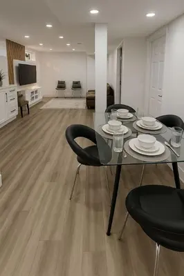 a dining table and chairs in a living room at Lux Basement Apartment Getaway in Brampton