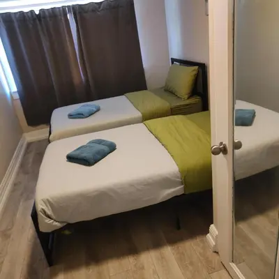 a room with three beds with towels on them at THE BLOOR AC SUITE-Free Wifi-Train-Bus Stop Next Door in Toronto
