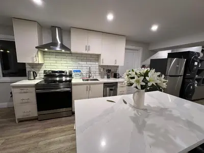 a kitchen with a table with a vase of flowers on it at Luxurious Pvt room & Pvt heated floor bathroom near Airport in Kitchener