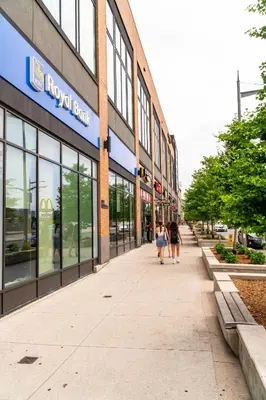 two people walking down a sidewalk in front of a building at Skyline Escape • 3BR Penthouse with Terrace in Toronto