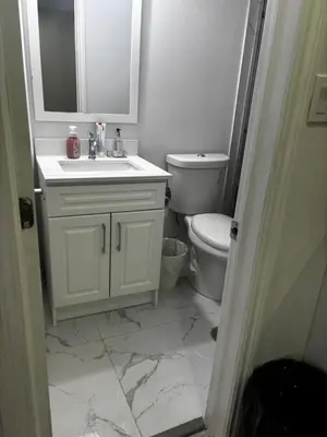 a white bathroom with a sink and a toilet at Ame place in Brampton