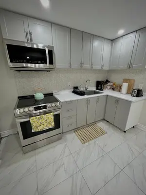 a kitchen with white cabinets and an oven in it at Your cozy Caribbean-inspired stay just 1 hour north of Toronto in Alliston