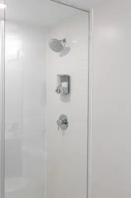 a shower stall with a glass door with a shower at Elegant 4BR Condo with City Views & Free Parking in Toronto